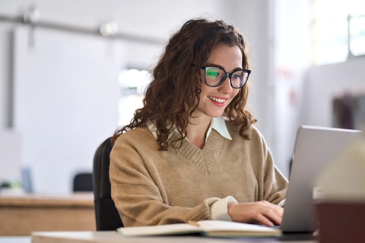 A membership administrator smiling at her laptop